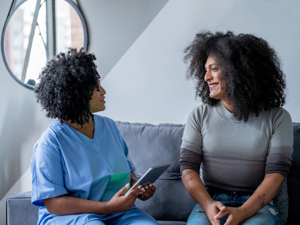 Black nurse consulting with a patient that identifies as a transgender woman